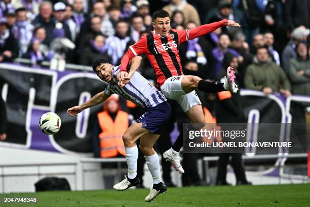 Toulouse's Chilean defender Gabriel Suazo fights for the ball with Nice's French midfielder Tom Alexis Louchet during the French L1 football match...