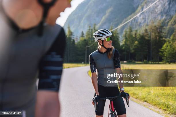 朝の山でのサイクリングを休むスポーティな白��人カップル - cycling vest ストックフォトと画像