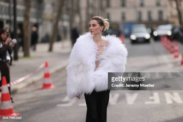 Fashion Week Guest was seen wearing a long black skirt, a bra out of jewelry, a white feather jacket before Courreges Fashion Show during the...