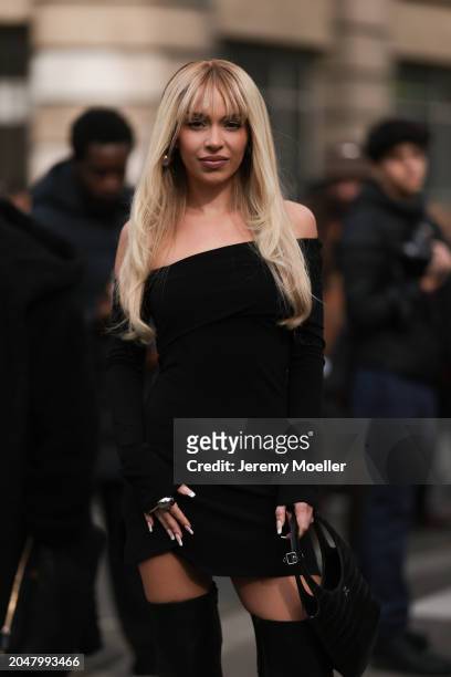 Bad Gyal was seen wearing a black leather bag, silver jewelry, pearl earrings, a shoulder free short dress and black boots before Courreges Fashion...