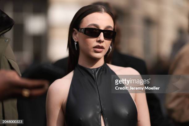 Emma Chamberlain was seen wearing black trousers, black Courreges shades, a black Courreges bag, silver jewelry as well as a leather top with a slit...