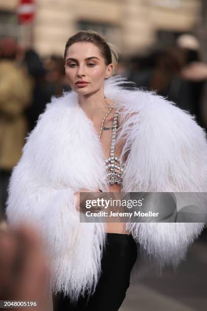 Fashion Week Guest was seen wearing a long black skirt, a bra out of jewelry, a white feather jacket before Courreges Fashion Show during the...