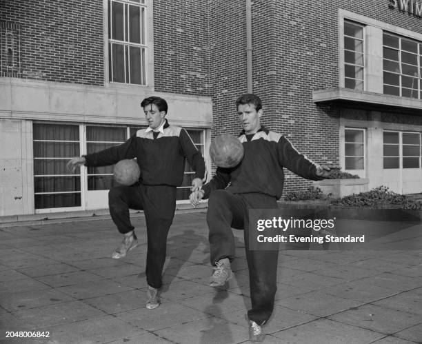 West Ham Football Club defenders John Bond and Malcolm Allison training in their tracksuits with footballs, London, March 8th 1956.