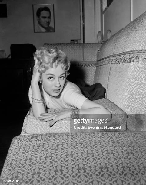 British actress Carole Lesley lying on a sofa, November 23rd 1956.