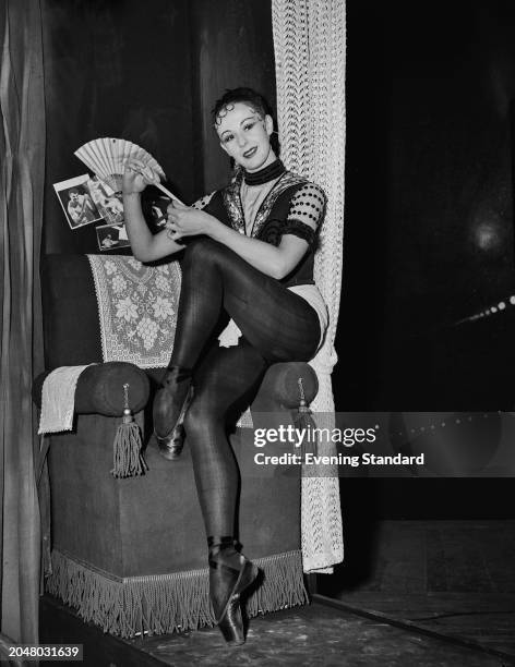 Ballet dancer Elaine Fifield holds a hand fan while sitting on the arm of a chair during rehearsals for 'The Miraculous Mandarin', Royal Opera House,...