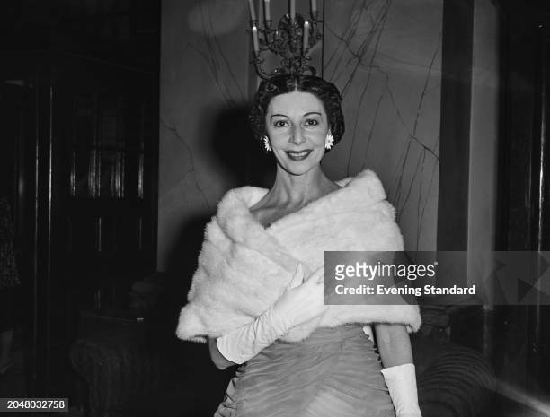British ballerina Alicia Markova wearing flower earrings, a fur shawl and evening dress, August 23rd 1956.