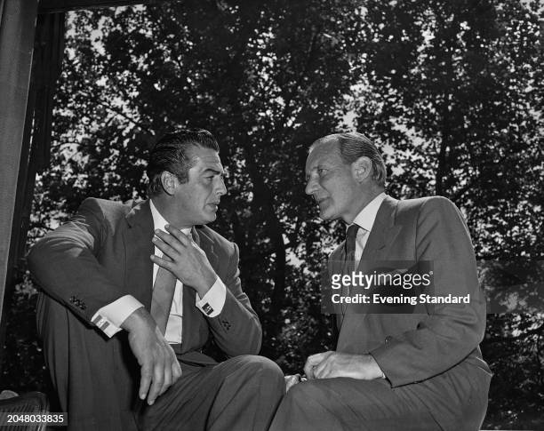 Actors Victor Mature and Trevor Howard during a press reception for their film 'Interpol', Savoy Hotel, London, August 17th 1956.
