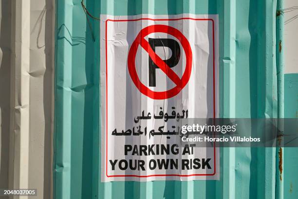 No Parking sign with "Parking at your own risk" bilingual text is seen posted at a construction site in Al Taawun Street on February 29 in Sharjah,...