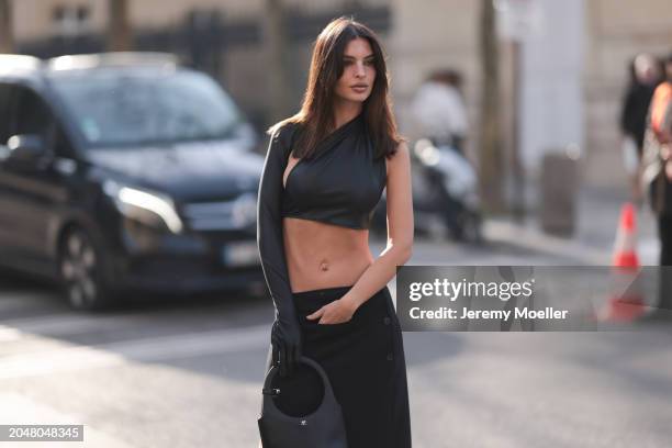 Emily Ratajkowski was seen wearing a long black skirt, a belly free black top as well as a black courreges bag before Courreges Fashion Show during...