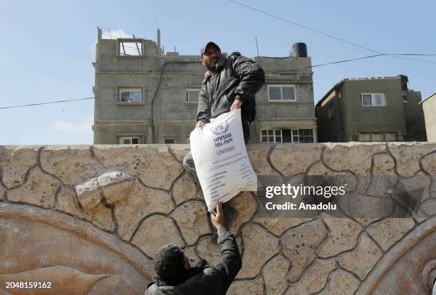 Palestinians flock to receive flour distributed by The United Nations Relief and Works Agency for Palestinian Refugees in the Near East in Gaza,...
