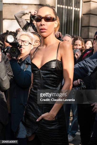 Ines Rau wears black leather mini dress on top of cut out pants, outside Courreges, during the Womenswear Fall/Winter 2024/2025 as part of Paris...