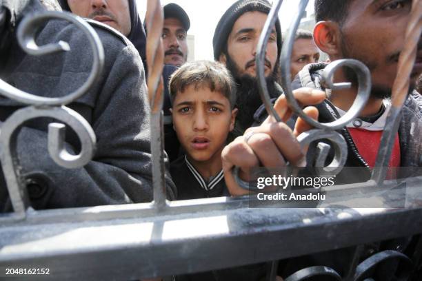 Palestinians flock to receive flour distributed by The United Nations Relief and Works Agency for Palestinian Refugees in the Near East in Gaza,...