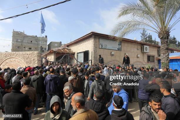 Palestinians flock to receive flour distributed by The United Nations Relief and Works Agency for Palestinian Refugees in the Near East in Gaza,...