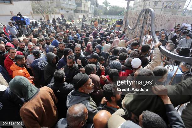 Palestinians flock to receive flour distributed by The United Nations Relief and Works Agency for Palestinian Refugees in the Near East in Gaza,...