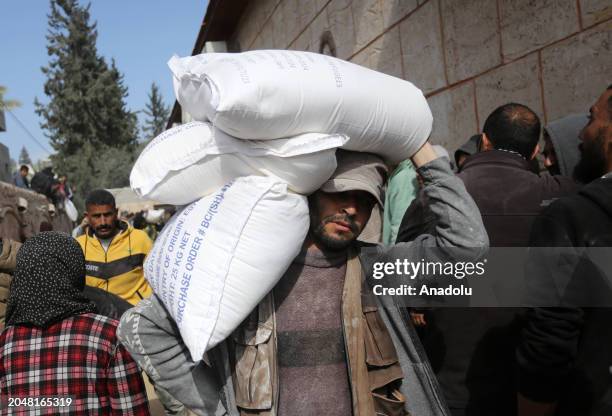 Palestinians flock to receive flour distributed by The United Nations Relief and Works Agency for Palestinian Refugees in the Near East in Gaza,...