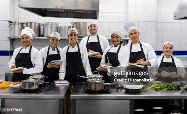 grupo de estudiantes sonriendo en una clase de cocina - industria alimentaria fotografías e imágenes de stock