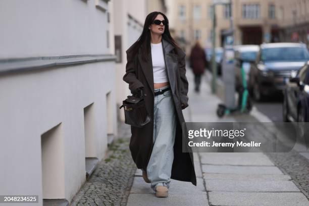 Anna Winter seen wearing Prada black Symbole sunglasses, Edited white cotton basic cropped shirt, The Mannei brown oversized wool long coat with...