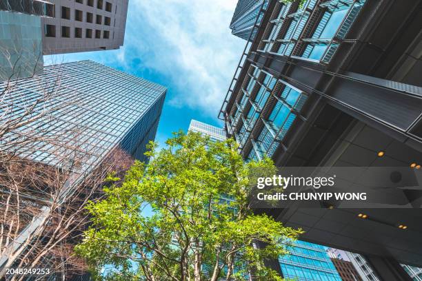 business towers and green leaves in marunouchi, tokyo - greenhouse gas stock pictures, royalty-free photos & images