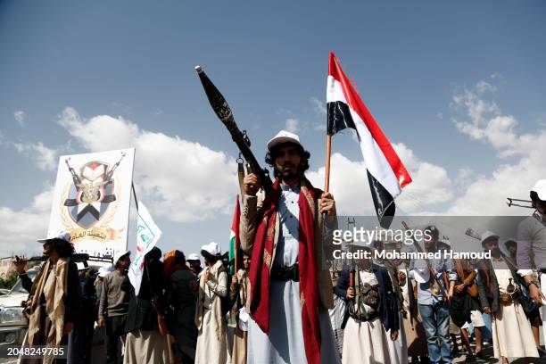 Yemen's Houthi followers carry weapons while taking part in a parade staged in solidarity with Palestinians and against Israel's war on the people of...