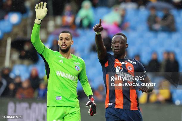 Montpellier's Nigerian forward Akor Adams and Strasbourg's Moroccan goalkeeper Alaa Bellaarouch react during the French L1 football match between...