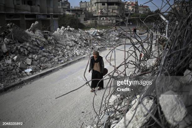 Palestinian woman walks past the rubble of houses destroyed by Israeli bombardment in Rafah in the southern Gaza Strip on March 3 amid the ongoing...