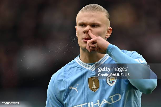 Manchester City's Norwegian striker Erling Haaland clears his nose during the English Premier League football match between Manchester City and...
