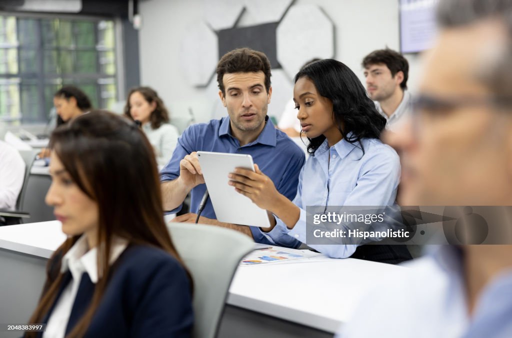 Team of MBA students in class using a digital tablet