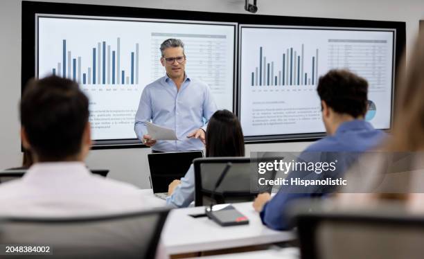 teacher teaching an mba class to a group of students - master of business administration stockfoto's en -beelden