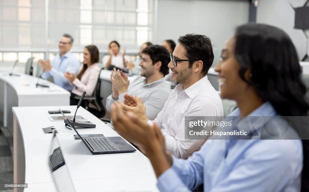Group of students applauding in class after finishing their master's degree