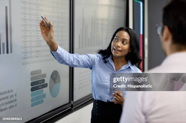 mba teacher explaining something to a student using a visual aid - master of business administration stockfoto's en -beelden