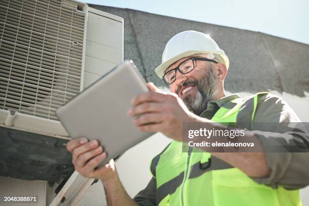 engineer repairs air conditioner - condenser stock pictures, royalty-free photos & images