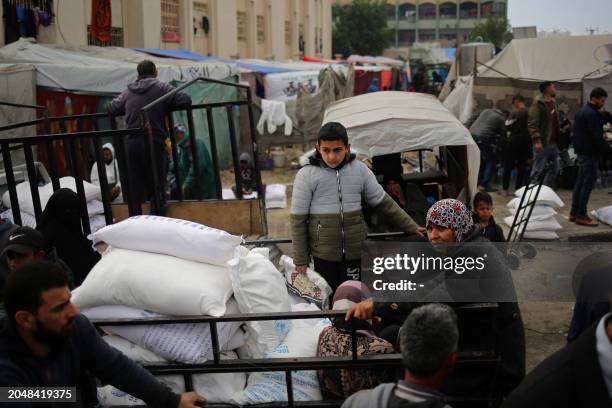 Palestinians sit in a vehicle loaded with sacks of humanitarian aid outside the distribution center of the United Nations Relief and Works Agency for...