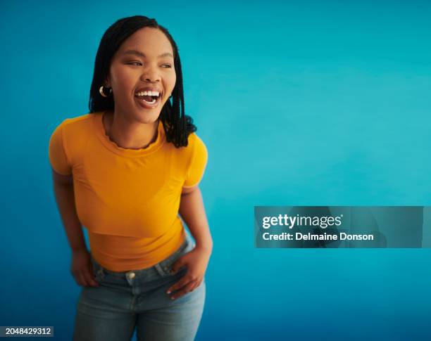 a beautiful black woman exuding confidence against a blue background - exuding stock pictures, royalty-free photos & images