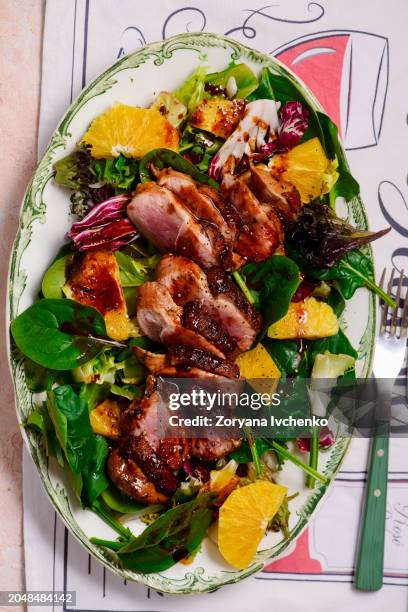 fried duck breast in honey soy glaze with mixed salad and oranges - duck meat stock pictures, royalty-free photos & images