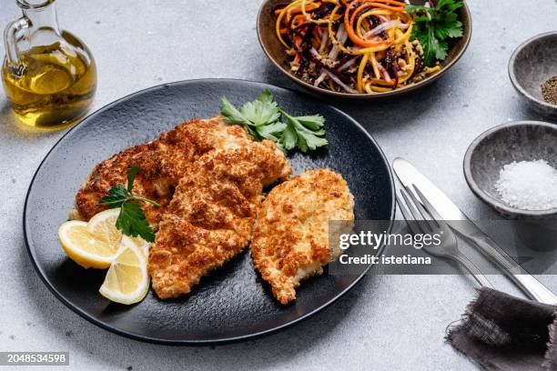 chicken schnitzel and julienne strips of purple, yellow, orange, white carrots salad - chicken strip stock pictures, royalty-free photos & images