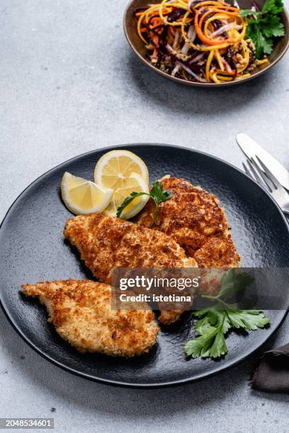chicken schnitzel and julienne strips of purple, yellow, orange, white carrots salad - chicken strip stock pictures, royalty-free photos & images