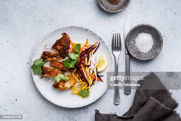 chicken schnitzel and julienne strips of purple, yellow, orange, white carrots salad - chicken strip stock pictures, royalty-free photos & images