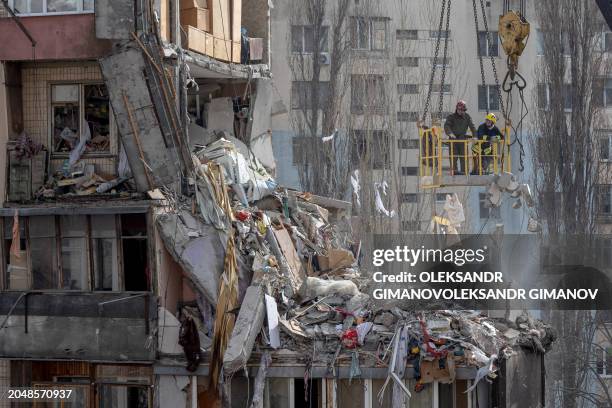 Rescuers clear debris from a multi-story building heavily damaged following a drone strike, in Odesa on March 3 amid the Russian invasion of Ukraine....