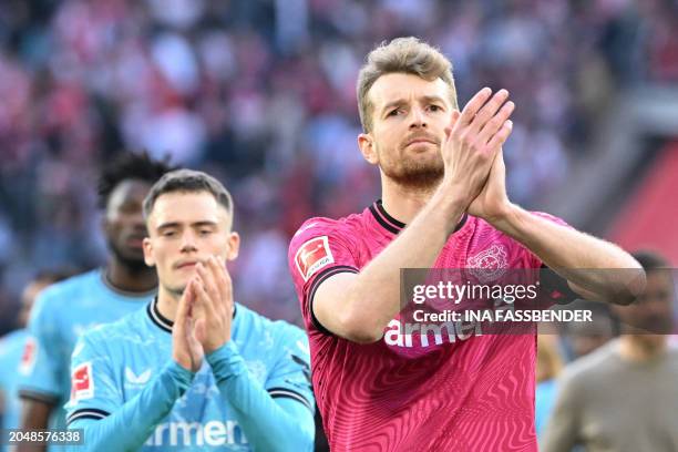 Bayer Leverkusen's German midfielder Florian Wirtz and Bayer Leverkusen's Finnish goalkeeper Lukas Hradecky react at the end of the German first...