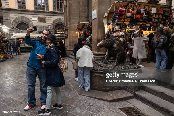 People take a selfie in front of the so called "Porcellino", a bronze fountain of a wild boar on February 29, 2024 in Florence, Italy. The historic...