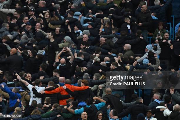 City fans celebrate their third goal by doing their Poznan celebration during the English Premier League football match between Manchester City and...