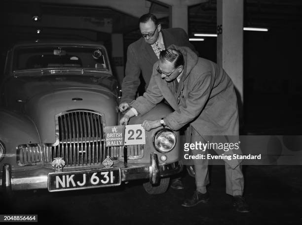 Car manufacturer and rally drivers Sydney Allard , right, and brother Leslie Allard with a sign on their Allard Motor Company car for entry in the...