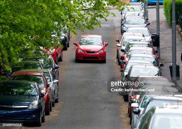 car in the middle of a road with cars parked on either side, scotland, uk - car road stock pictures, royalty-free photos & images