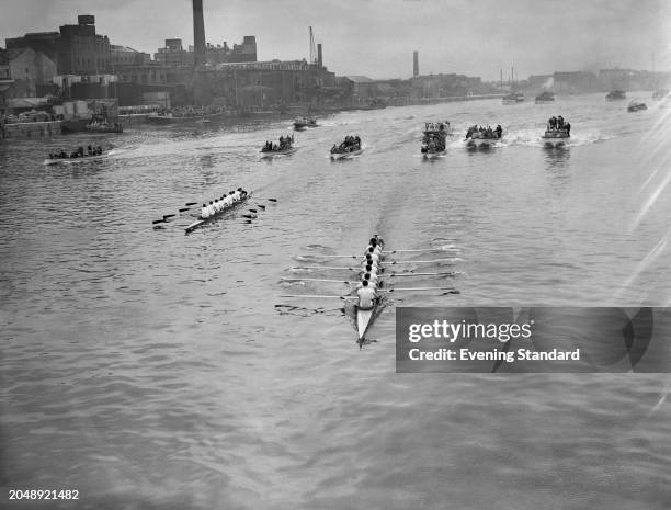 The Oxford and Cambridge scull boat crews followed by other boats during the Boat Race, River Thames, London, March 24th 1956.