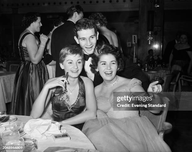 Actresses Jill Ireland , left, and Barbara Lyon with actor Richard Lyon during a social event, December 2nd 1955.
