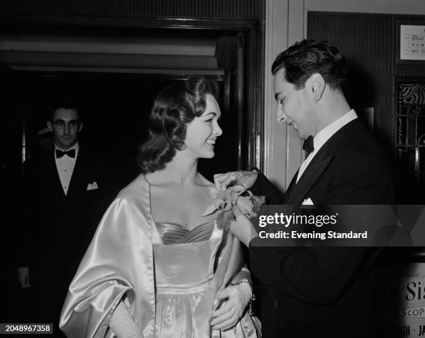 Actress Jacqueline Curtiss has her dress adjusted by journalist Michael Winner , September 26th 1955.