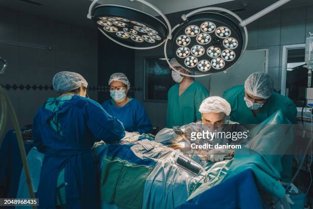 team of surgeons and assistants during a coronary artery bypass surgery. - civil defence stock pictures, royalty-free photos & images