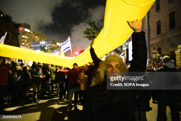 An Israeli woman holds up a giant 'yellow ribbon' - the symbol for solidarity with the Israeli hostages in Gaza. Families of the 134 Israeli hostages...