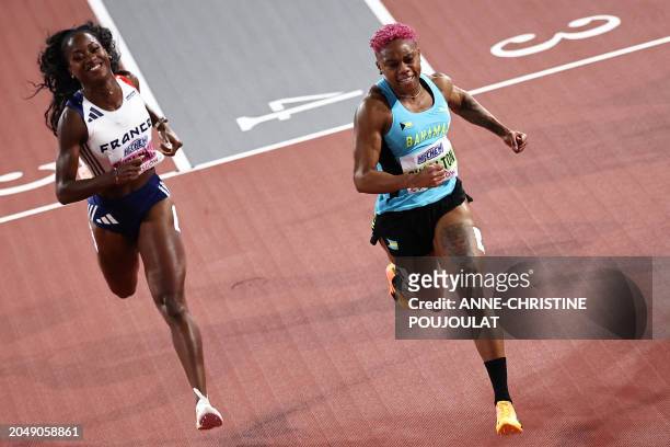 First-placed Bahamas' Devynne Charlton crosses the finish line past second-placed France's Cyrena Samba-Mayela competes in the Women's 60m hurdles...