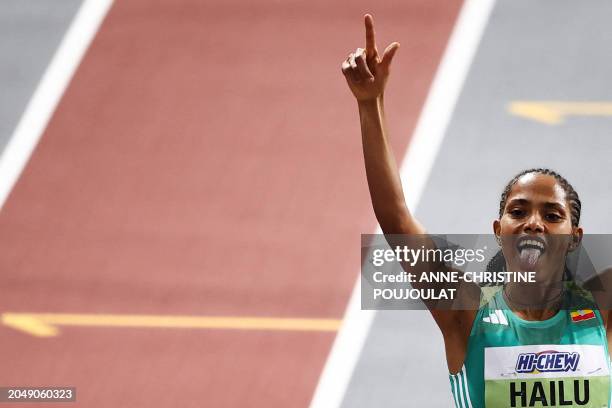 First-placed Ethiopia's Freweyni Hailu celebrates as she crosses the finish line to win the Women's 1500m final during the Indoor World Athletics...